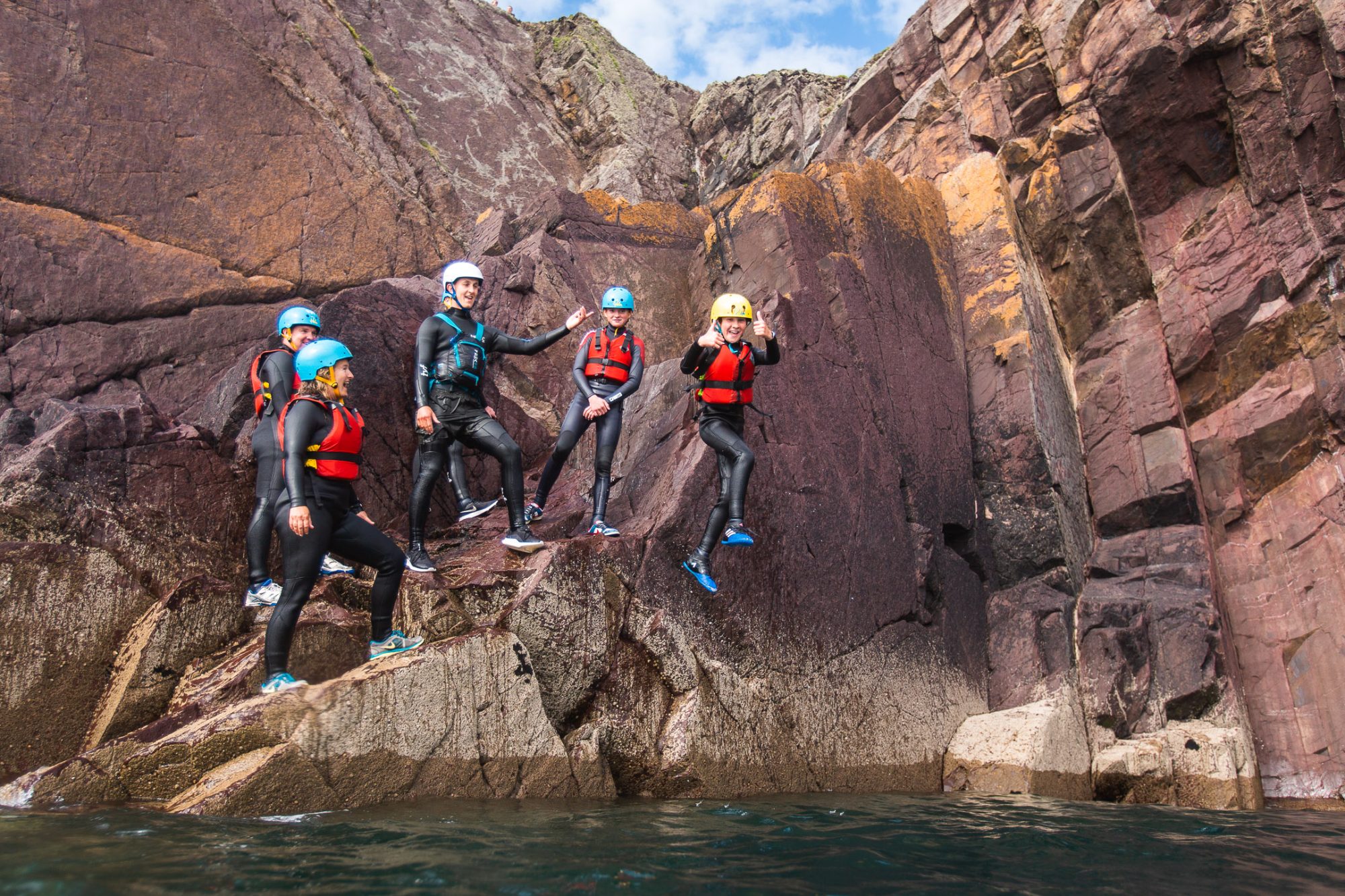 A group jumping into the sea under expert tution