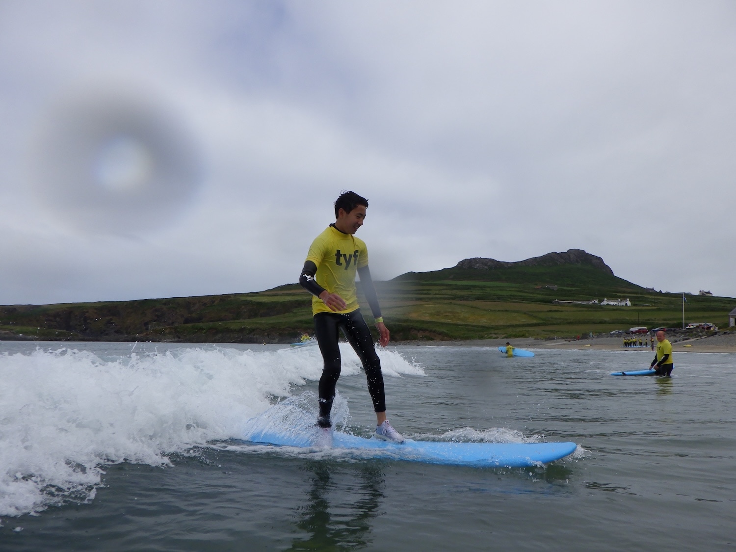 Young particapant riding a small wave stood up