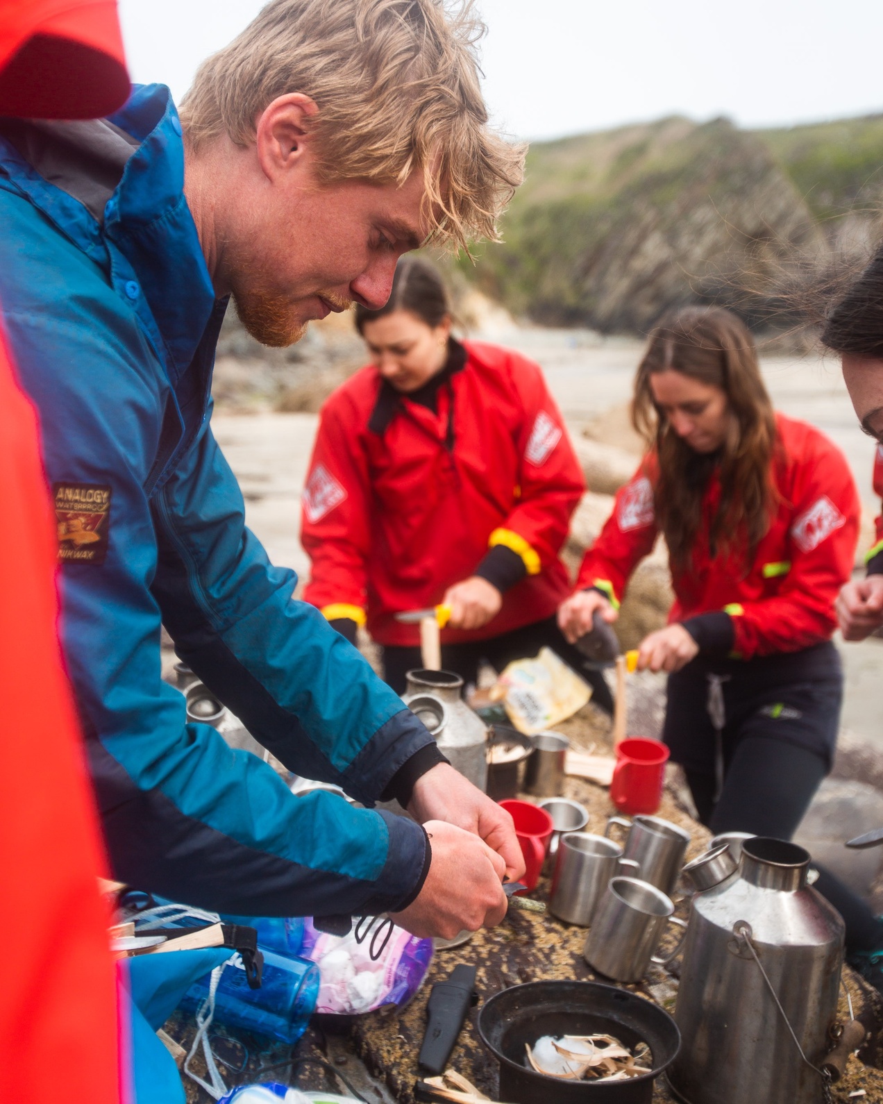 A group making hot chochlate on a beach using kelly kettles during their Coastal Explorer