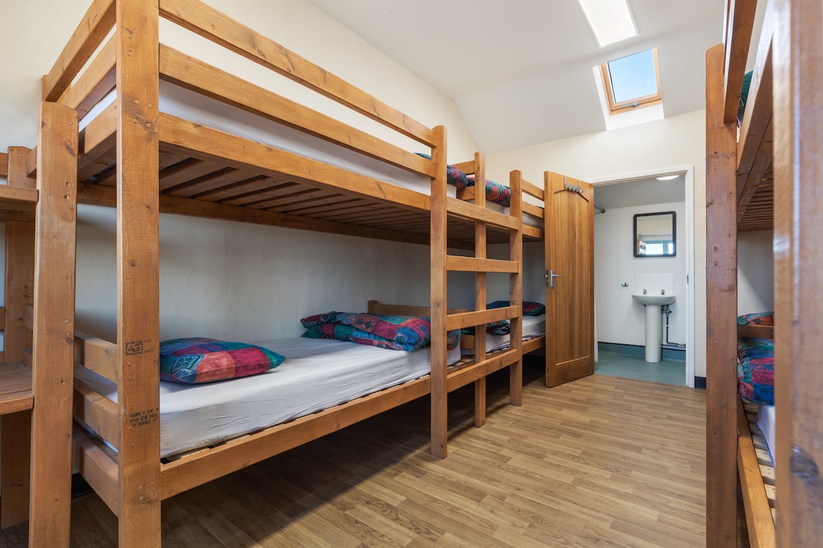 Shared bunkroom accommodation with wooden bunk beds and ensuite for course participants