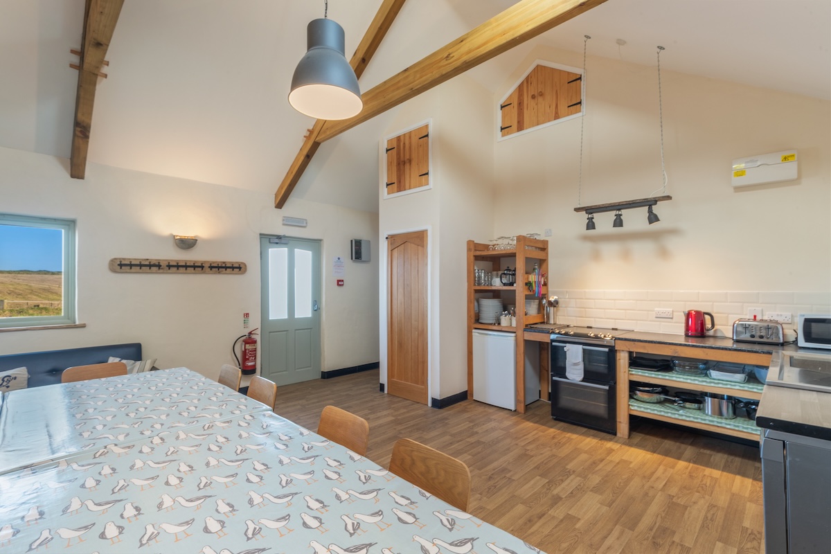 Bright communal kitchen and dining area used by outdoor instructor trainees