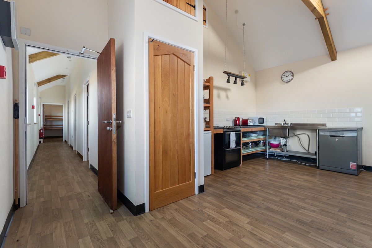 Indoor corridor leading to bunkroom accommodation at the training centre